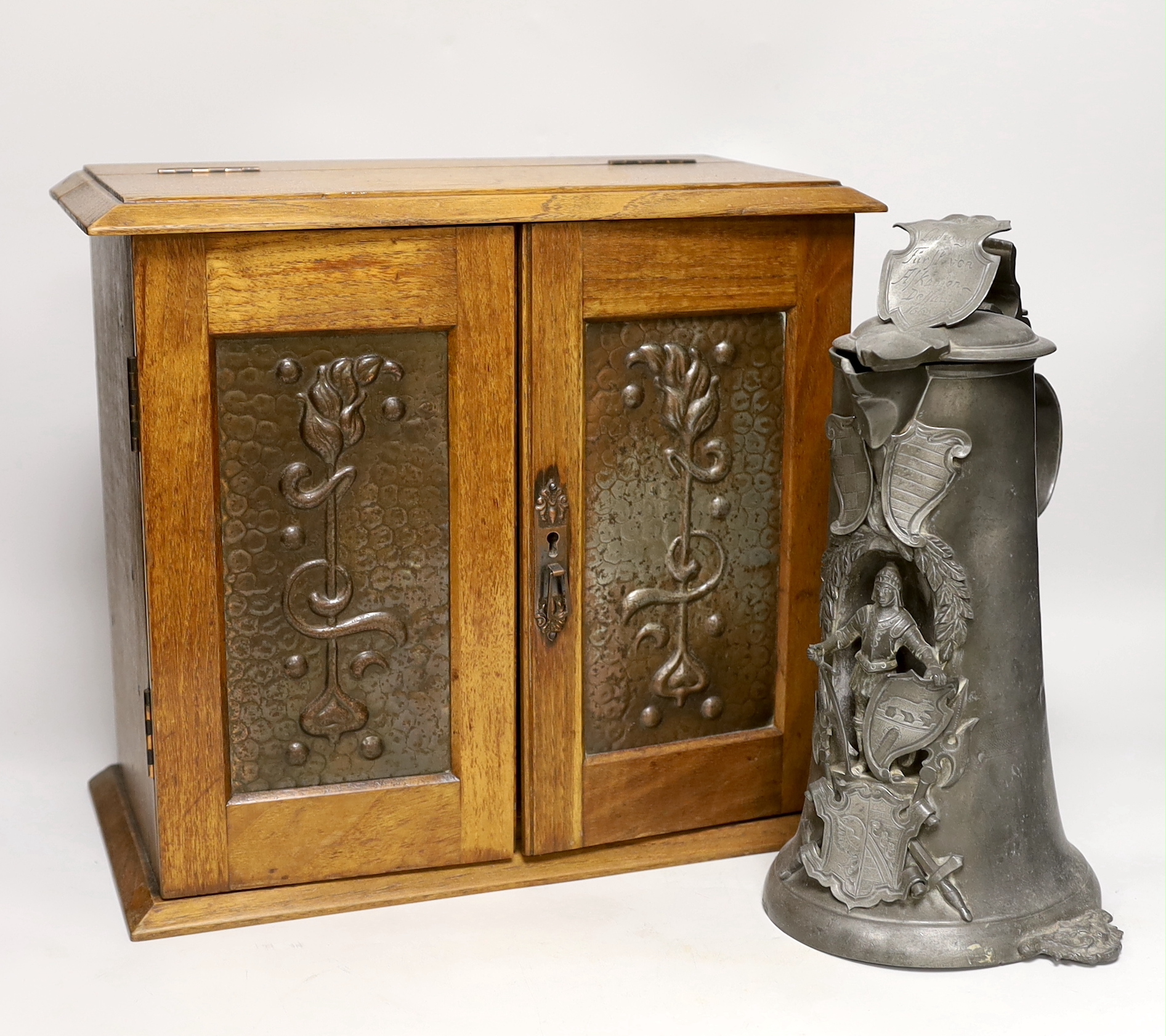 A German pewter commemorative flagon and an Art Nouveau smoker's cabinet